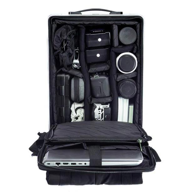 Black ALEON 17" padded camera insert with adjustable dividers, filled with gear inside an open backpack.