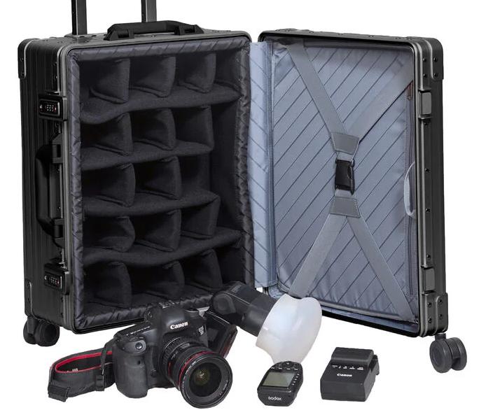 Black ALEON 30" aluminum camera case open, revealing padded inserts and dividers, with a camera and accessories beside it.